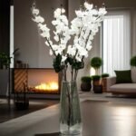 Artificial cherry blossom flowers in white displayed in a clear glass vase for interior decoration