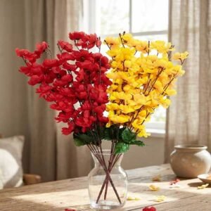 Artificial cherry blossom flowers in red and yellow displayed in a clear glass vase for interior decoration