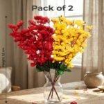 Artificial cherry blossom flowers in red and yellow displayed in a clear glass vase for interior decoration